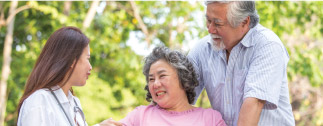 Patient and spouse outdoors with caregiver