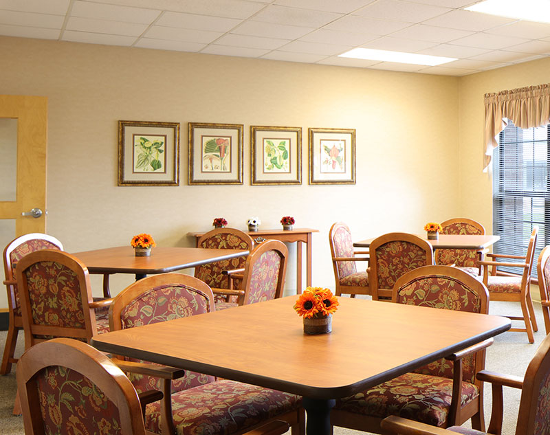 Dining room with four person tables in Madison, Virginia nursing home.